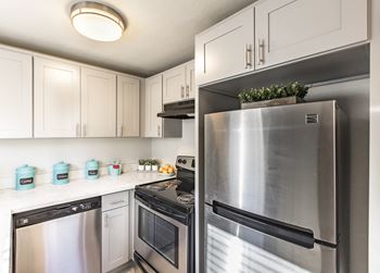 A kitchen with stainless steel appliances and white cabinets